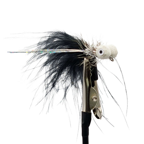 Fishing fly with black feathers and a white body on a white background