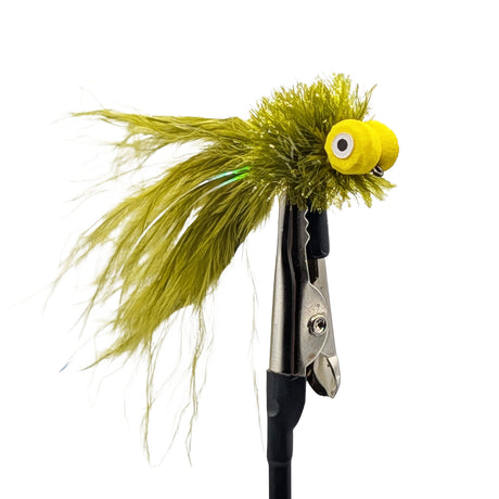 Fishing lure with green feathers and a yellow eye on a white background