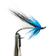 Sea Trout Fly Fishing fly with blue and black fibers on a white background